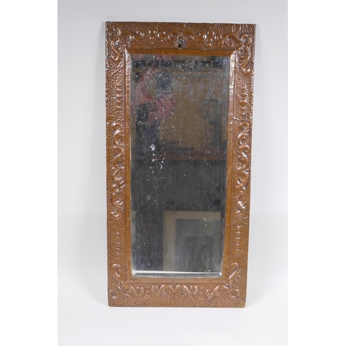 1123 - An antique beaten copper wall mirror with repousse swag decoration, 56 x 28cm