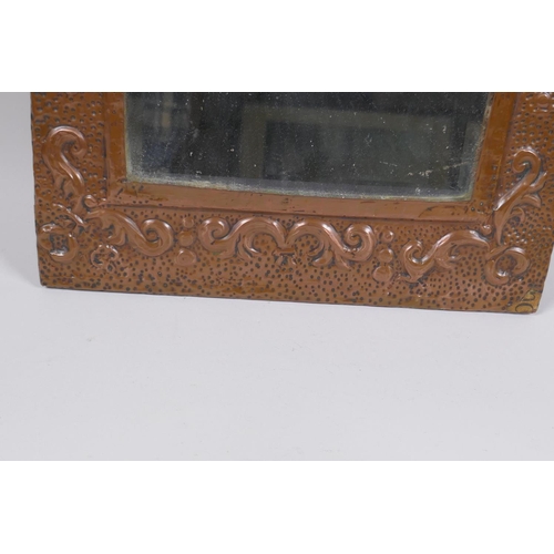 1123 - An antique beaten copper wall mirror with repousse swag decoration, 56 x 28cm