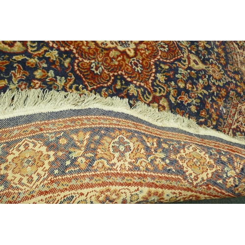 1126 - A wool carpet with Persian style designs on a red field with blue borders, 180cm diameter