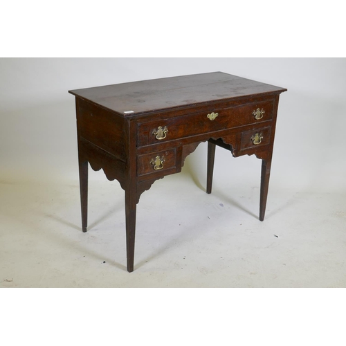 1129 - An C18th oak lowboy with long drawer over two small, with brass plate handles, raised on square tape... 