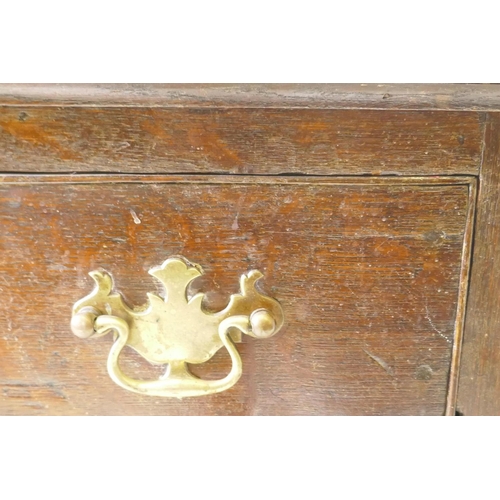 1129 - An C18th oak lowboy with long drawer over two small, with brass plate handles, raised on square tape... 