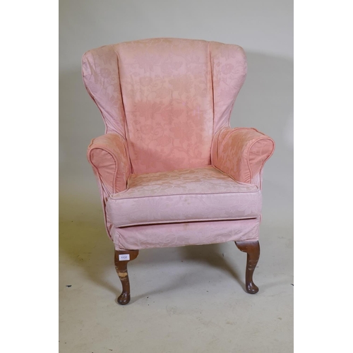 1131 - A wing back armchair, raised on cabriole supports