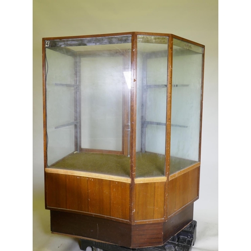 1137 - A mid century illuminated mahogany shop display cabinet with two glass shelves, glass top and concav... 