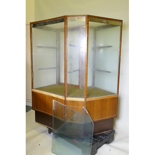 1137 - A mid century illuminated mahogany shop display cabinet with two glass shelves, glass top and concav... 