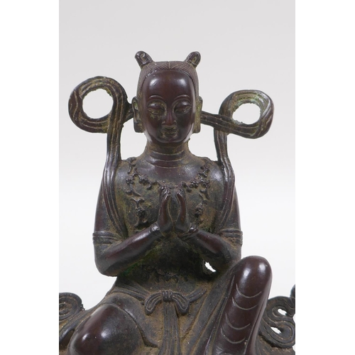 125 - A Sino Tibetan bronze of a deity in prayer, 16cm high