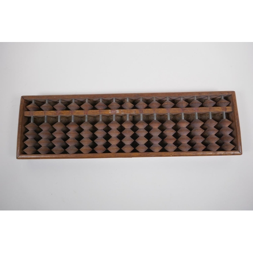 127 - A Chinese hardwood abacus with carved characters and inscription verso, 33 x 10cm