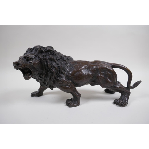 129 - After Rodin, a bronze figure of a prowling lion, 31cm long