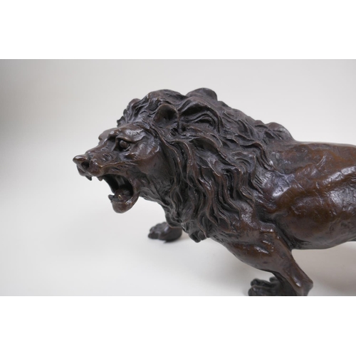 129 - After Rodin, a bronze figure of a prowling lion, 31cm long