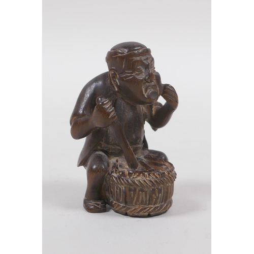 131 - A Japanese carved wood netsuke in the form of a man making mochi, 5cm high