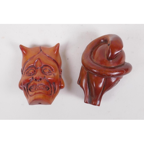 134 - A Japanese carved boxwood netsuke in the form of an oni mask, and another carved in the form of a sa... 