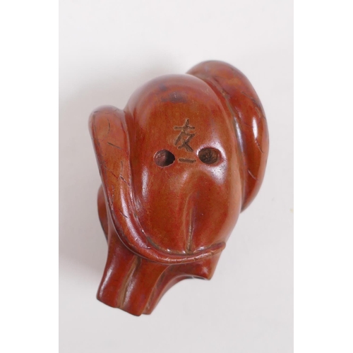 134 - A Japanese carved boxwood netsuke in the form of an oni mask, and another carved in the form of a sa... 