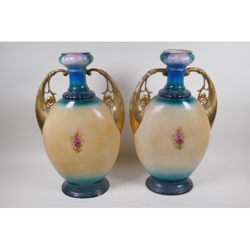 137 - A pair of Edwardian porcelain vases with gilt handles and floral decoration, 44cm high, AF