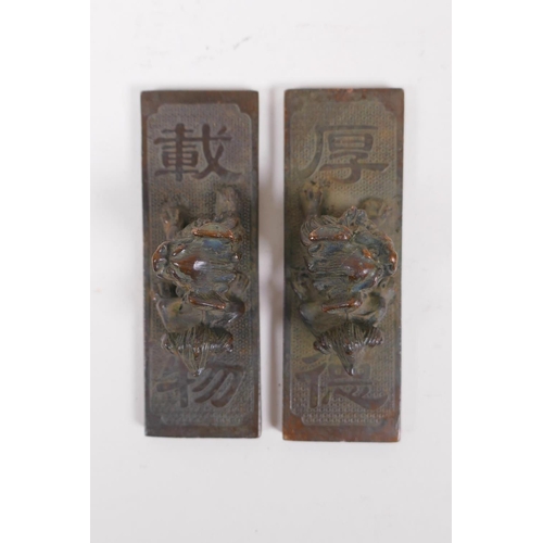 140 - A pair of Chinese bronze scroll weights with decorative characters and fo dog mounts, 4 x 11cm