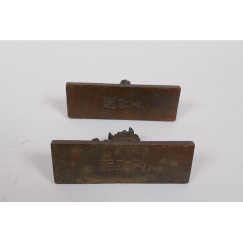 140 - A pair of Chinese bronze scroll weights with decorative characters and fo dog mounts, 4 x 11cm