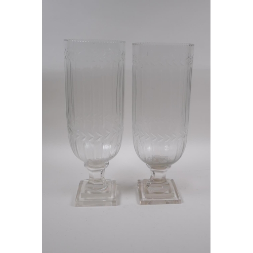 142 - A pair of glass hurricane vases with cut glass decoration, 34cm high, 12cm high