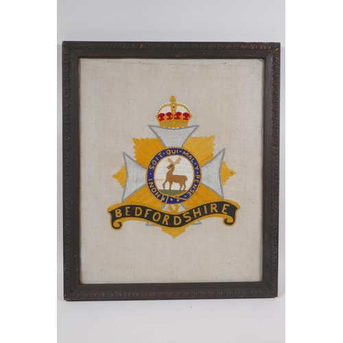 152 - A 1919 hand embroidery of the Bedfordshire Regimental badge/coat of arms, in a period frame, 36 x 43... 