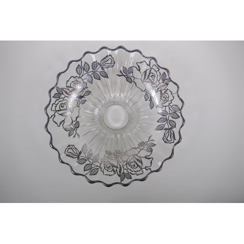 156 - A silver overlaid glass fruit bowl decorated with a rose design, 32cm diameter