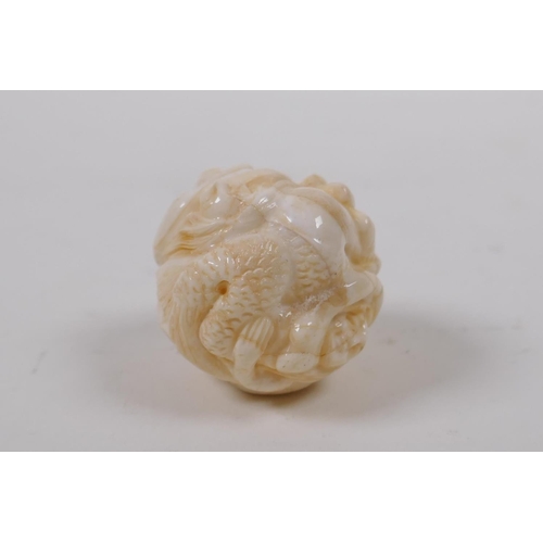 172 - A Japanese bone ball weight with carved mermaid decoration 3cm diameter