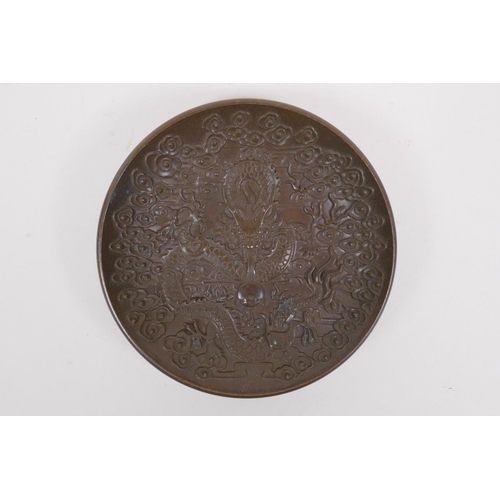 176 - A Chinese bronze trinket dish with raised dragon and flaming pearl decoration, impressed 4 character... 