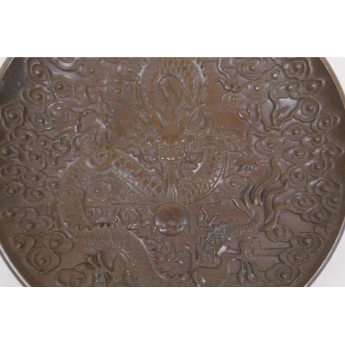 176 - A Chinese bronze trinket dish with raised dragon and flaming pearl decoration, impressed 4 character... 