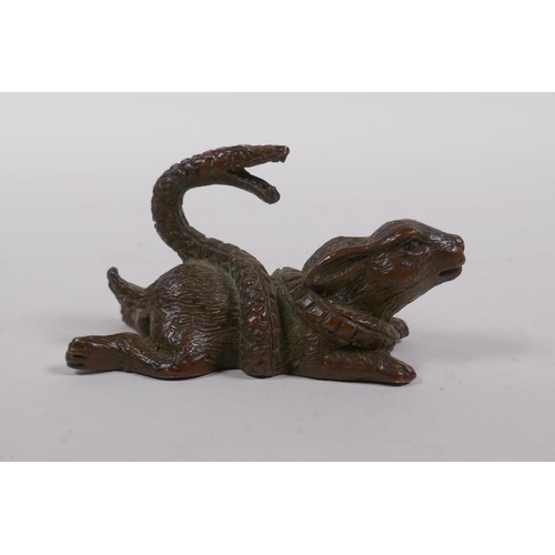 185 - A Japanese style bronze okimono rabbit entwined by a snake, 8cm long