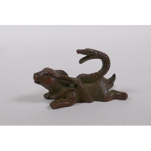 185 - A Japanese style bronze okimono rabbit entwined by a snake, 8cm long