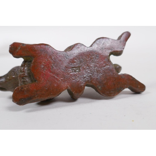 185 - A Japanese style bronze okimono rabbit entwined by a snake, 8cm long