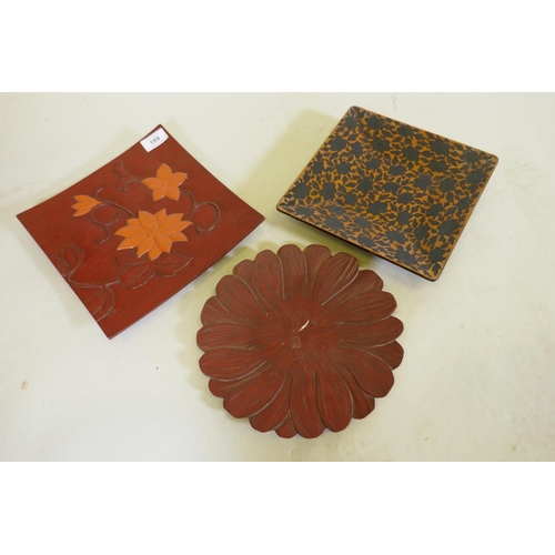 189 - Three oriental carved and lacquered dishes with lotus and chrysanthemum decoration, marked to the ba... 