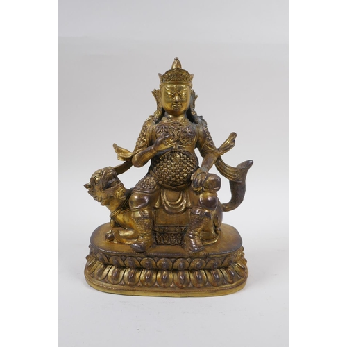 193 - A Sino Tibetan gilt bronze figure of an armoured deity, seated on a kylin, 22cm high