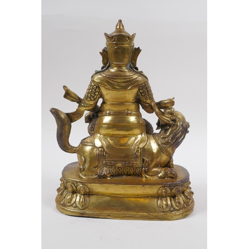 193 - A Sino Tibetan gilt bronze figure of an armoured deity, seated on a kylin, 22cm high