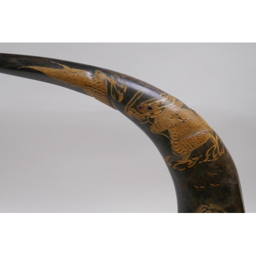 203 - A pair of oriental carved horns decorated with tigers and dragons, 36cm high