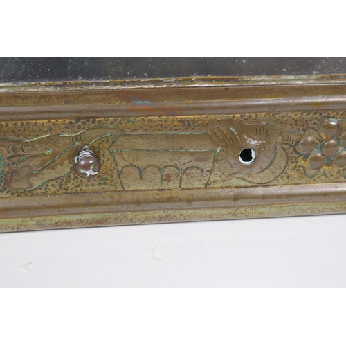 204 - An Arts and Crafts brass wall mirror with repousse fruit and flower decoration, 23 x 38cm