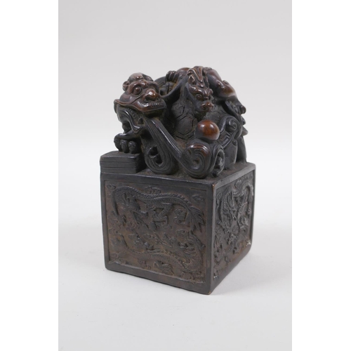 210 - A Chinese filled bronze seal with a Longgui and kylin knop, 8cm x 8cm, 13cm high