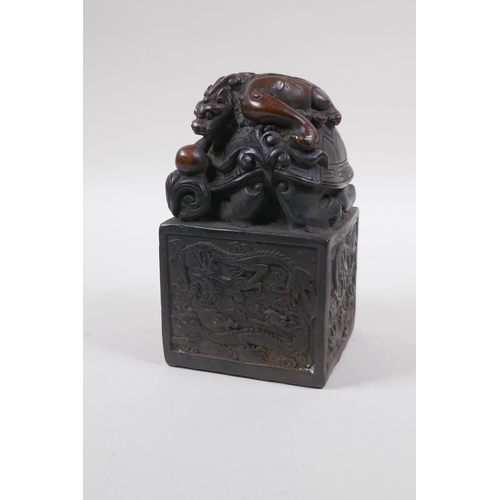 210 - A Chinese filled bronze seal with a Longgui and kylin knop, 8cm x 8cm, 13cm high