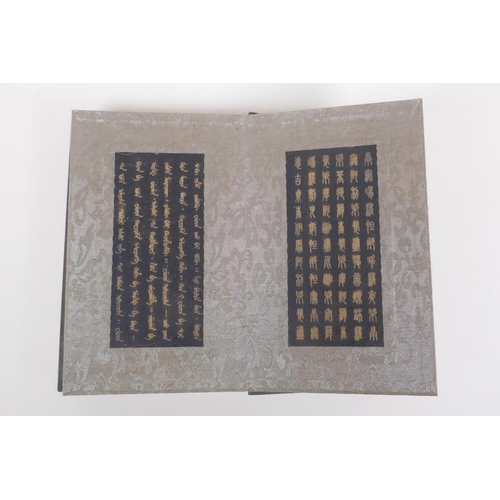 228 - A Chinese wood and silk bound book containing black hardstone tablets with chased and gilt character... 