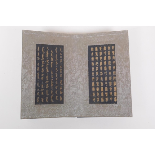 228 - A Chinese wood and silk bound book containing black hardstone tablets with chased and gilt character... 