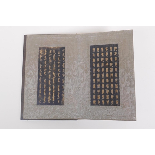 228 - A Chinese wood and silk bound book containing black hardstone tablets with chased and gilt character... 