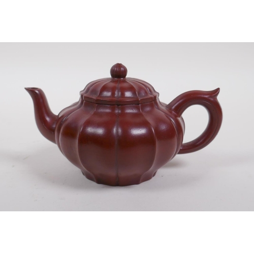 23 - A Chinese Yixing tea pot of lobed form with protective wood box, impressed seal mark to base, 9cm di... 