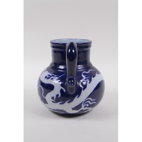 230 - A Chinese blue ground porcelain wine jug with white underglaze dragon decoration, 15cm high