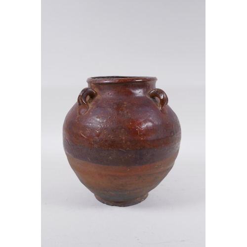 232 - A antique glazed terracotta jar with four lug handles, 20cm high