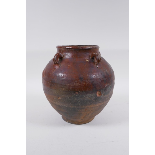 232 - A antique glazed terracotta jar with four lug handles, 20cm high