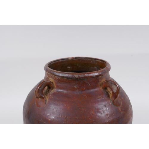 232 - A antique glazed terracotta jar with four lug handles, 20cm high