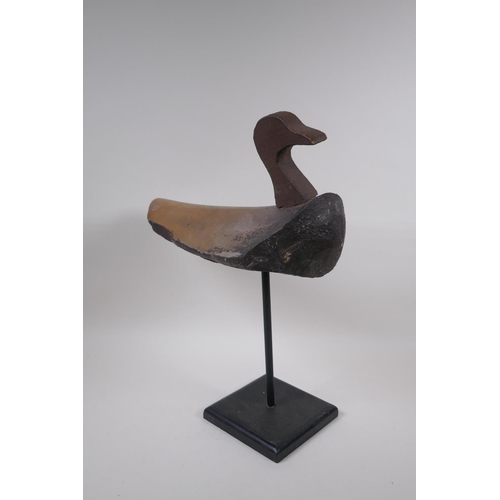 234 - A vintage style decoy duck mounted on a display stand, 47cm high, 37cm long