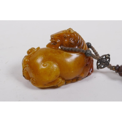 248 - A Chinese reconstituted amber soapstone toggle in the form of a horse, 8cm long