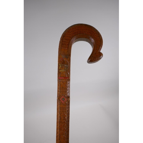 257 - An East European walking stick with carved and stained Christian iconography decoration, 90cm long