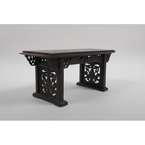 26 - A Chinese carved and pierced hardwood stand in the form of a miniature altar table, 22cm wide