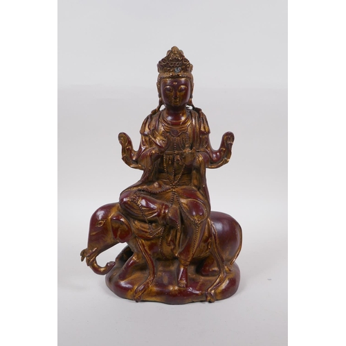 263 - A Chinese coppered bronze of Quan Yin seated upon an elephant with the remnants of gilt patina, 32cm... 