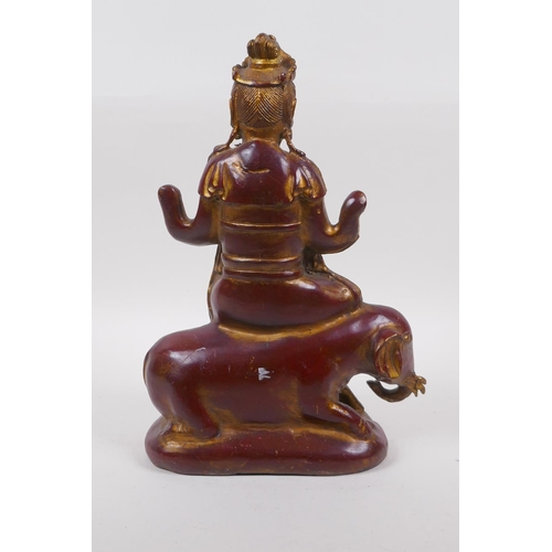 263 - A Chinese coppered bronze of Quan Yin seated upon an elephant with the remnants of gilt patina, 32cm... 