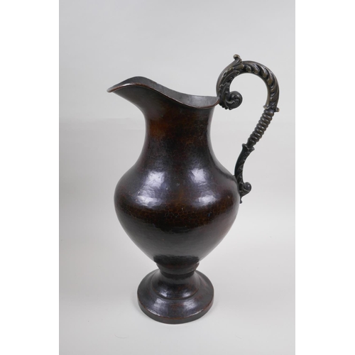 46 - A patinated hammered copper urn with bronze handle, 39cm high