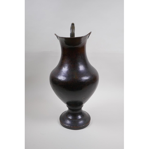 46 - A patinated hammered copper urn with bronze handle, 39cm high